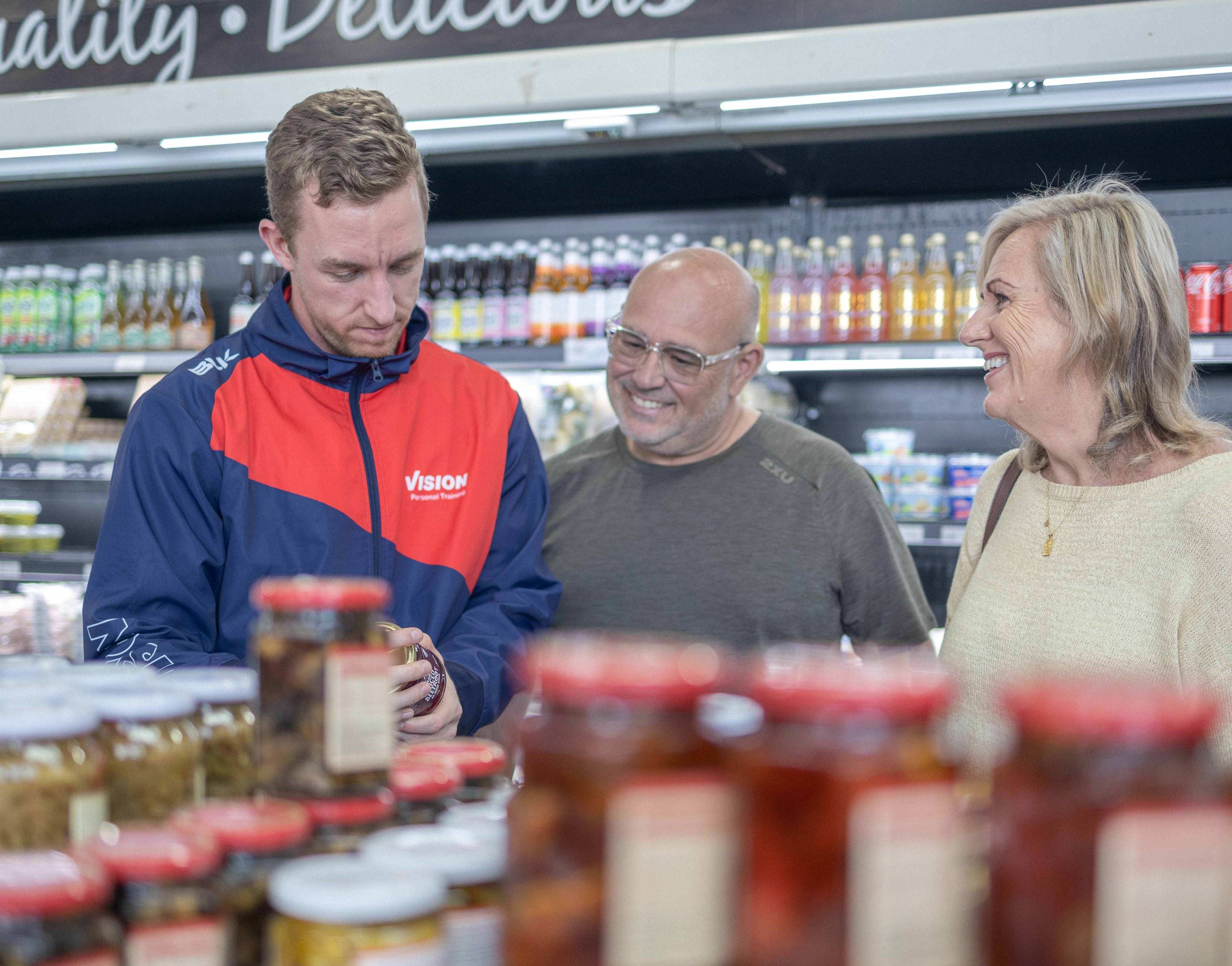 Vision Personal Training trainer educating clients on healthy meals at a shopping tour._